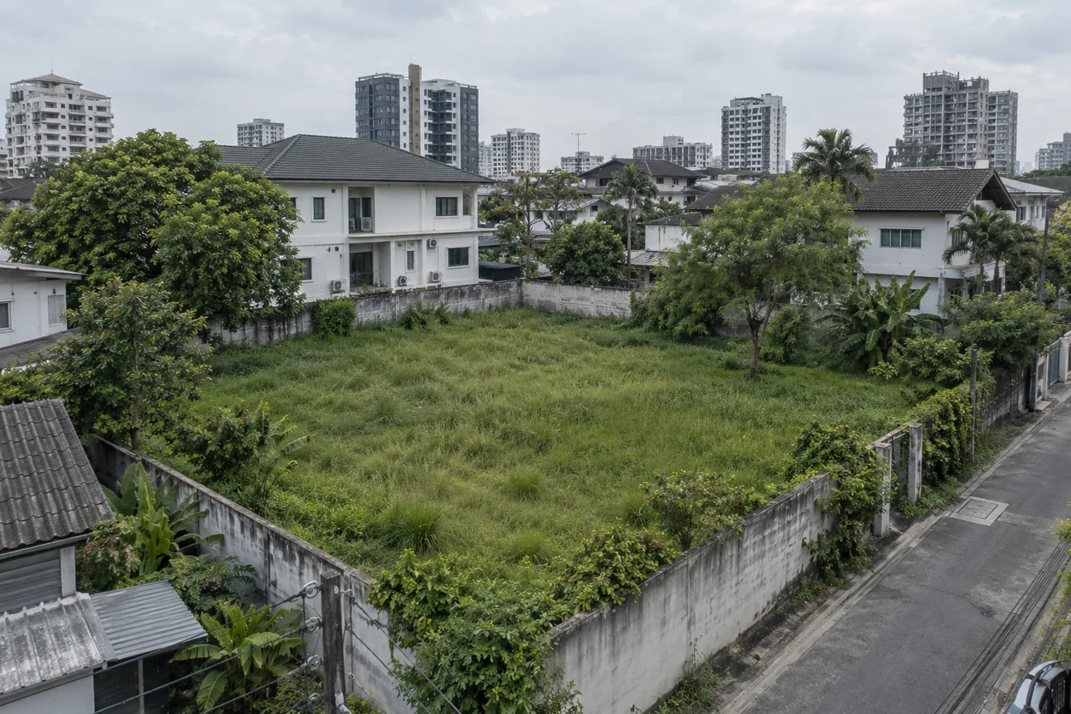 Vacant urban land with surrounding homes and a neighbouring street.