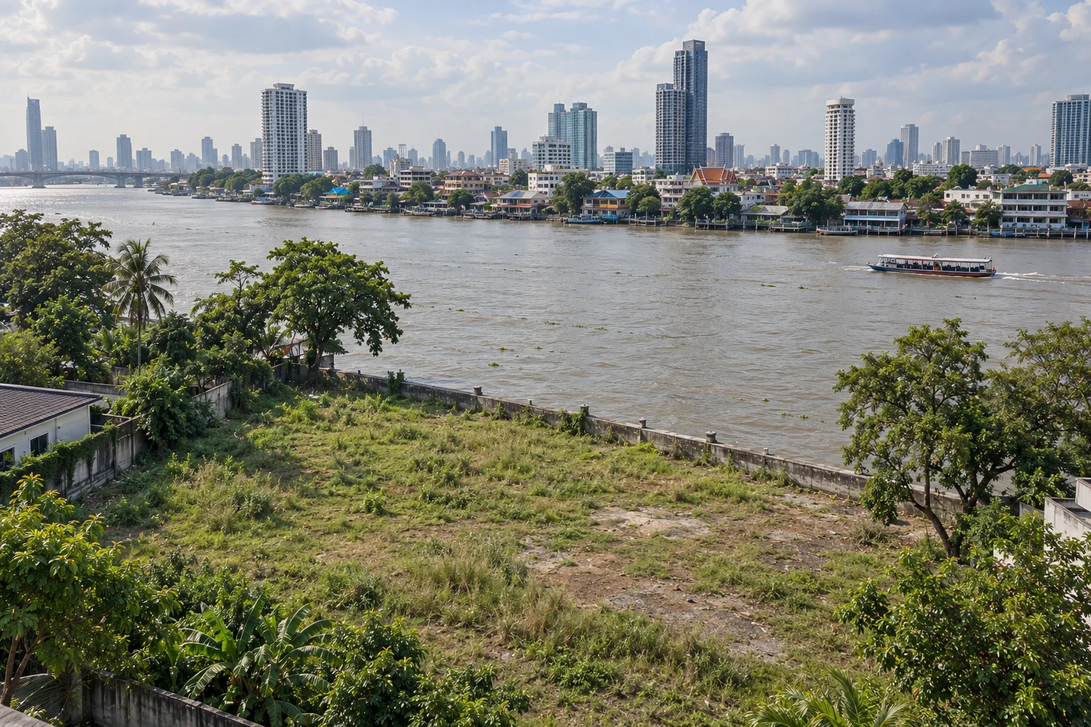 Vacant land beside the Chao Phraya River, with the Bangkok skyline beyond.